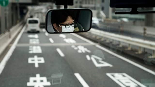 A representational image of a bus driver being reflected in the mirror in Tokyo. AP 