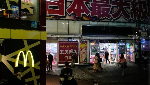People walk near a pachinko parlor ahead of the 2020 Summer Olympics. AP 
