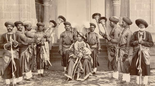 Shahu Chhatrapati seated with palace servants. Image via WikimediaCommons