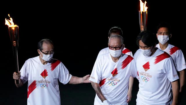 The torch-bearers make their way around the stadium during the Olympics opening ceremony. AP 