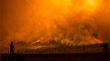 Fires rage in several states as heat wave broils US West, strains power grids