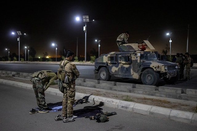 Members of the Afghan Special Forces pray on a highway before a combat mission against Taliban, in Kandahar province. Image courtesy: Danish Siddiqui/Reuters