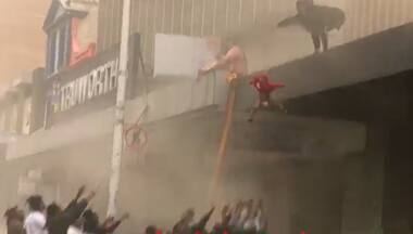 Watch: Mother throws 2-yr-old into arms of passersby after rioters set ablaze Durban building