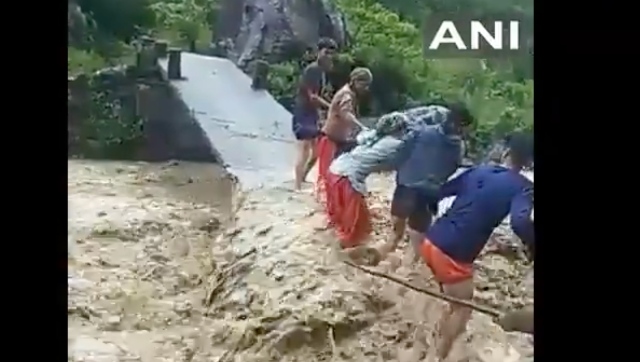 Watch: People cross river on half-damaged bridge in Uttarakhand amid gushing waves Watch: People cross river on half-damaged bridge in Uttarakhand amid gushing waves