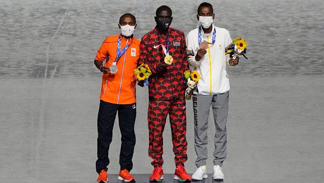 Gold medalist Eliud Kipchoge, of Kenya, center, stands with silver medalist Abdi Nageeye, of Netherlands, left, and bronze medalist Bashir Abdi, of Belgium, during the closing ceremony in the Olympic Stadium at the 2020 Summer Olympics. AP/Charlie Riedel