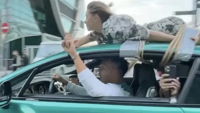 Watch: Russian influencer drives with girlfriend tied to roof in bizarre 'trust test'; police launches probe Watch: Russian influencer drives with girlfriend tied to roof in bizarre 'trust test'; police launches probe