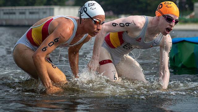 Spain's Susana Rodriguez, right, and her guide Sara Loehr exit the water at the end of the swimming stage in the women's triathlon PTV1 at Odaiba Marine Park on Saturday. OIS via AP Photo