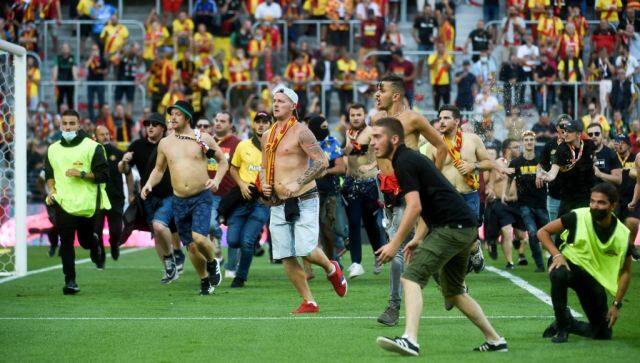 Lens' supporters invade the pitch during the French L1 football match between RC Lens (RCL) and Lille (LOSC) at Stade Bollaert-Delelis in Lens, northern France, on September 18, 2021. (Photo by FRANCOIS LO PRESTI / AFP)