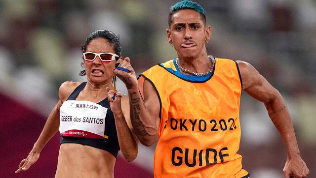 Brazil’s Jerusa Geber Dos Santos and her guide Brazil’s Gabriel Aparecido Dos Santos Garcia compete in the Women’s 100m T11 Semi-Final at the Olympic Stadium during the Tokyo 2020 Paralympics. OIS via AP