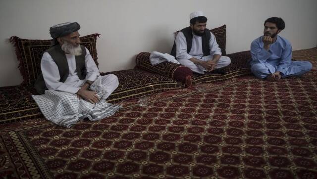 Ghulam Ghous, left, sits with his sons Ghulam Zikria, center, and Zakir Anwari, in their home in Kabul. Ghous lost his other son Zaki Anwari. AP