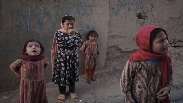 Afghan girls look up and listen as a neighbour describes when two men fell from a US Air Force C-17 and landed on the rooftop of his house in Kabul on August 16. AP 