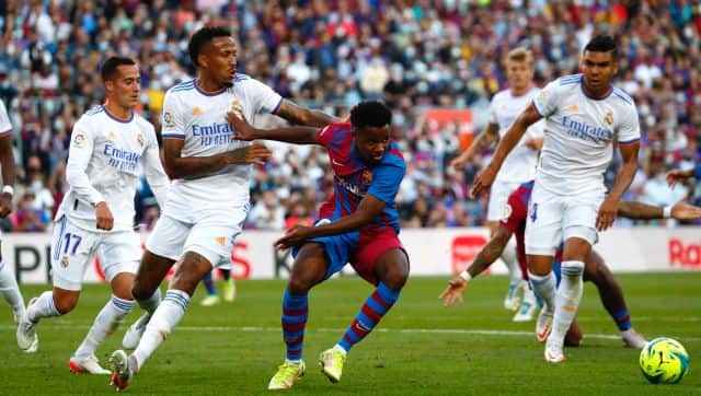 Real Madrid's Eder Militao, left, challenges Barcelona's Ansu Fati, center, during the Spanish La Liga soccer match between FC Barcelona and Real Madrid at the Camp Nou stadium in Barcelona, Spain, Sunday, Oct. 24, 2021. (AP Photo/Joan Monfort)