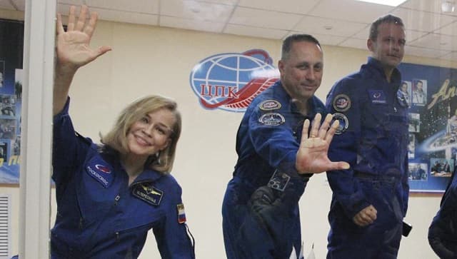 In this handout photo released by Roscosmos, actress Yulia Peresild, left, director Klim Shipenko, right, and cosmonaut Anton Shkaplerov, members of the prime crew of Soyuz MS-19 spaceship gesture after a news conference at the Russian launch facility in the Baikonur Cosmodrome, Kazakhstan, Monday, 4 October, 2021 (Roscosmos Space Agency via AP)