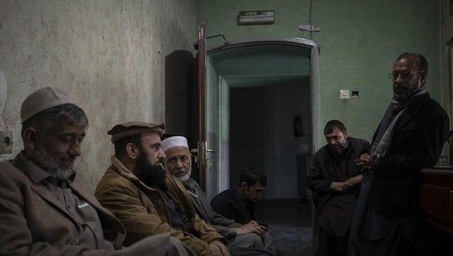 Staff members sit inside the ticket office of the Ariana Cinema in Kabul, Afghanistan on Monday, Nov. 8, 2021 (AP Photo/Bram Janssen)