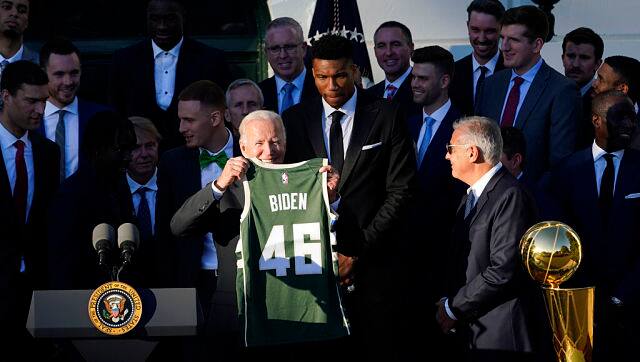 President Joe Biden holds up a Milwaukee Bucks jersey that he was presented with from team owner Marc Lasry. AP