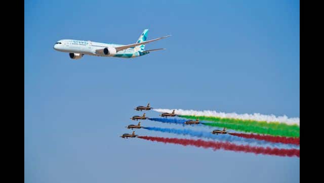 An Etihad Boeing 787 Dreamliner flies alongside the Emirati Forsan military stunt flying team at the Dubai Air Show . AP Photo