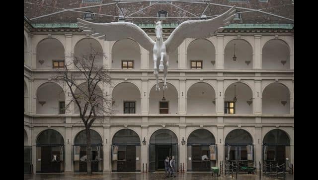 Employees walk outside a horse riding school in Vienna, Austria. AP