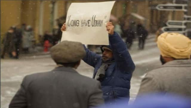Shoojit Sircar holds up a placard during shoot that reads 'Long live Udham'. Twitter/@shoojitsircar