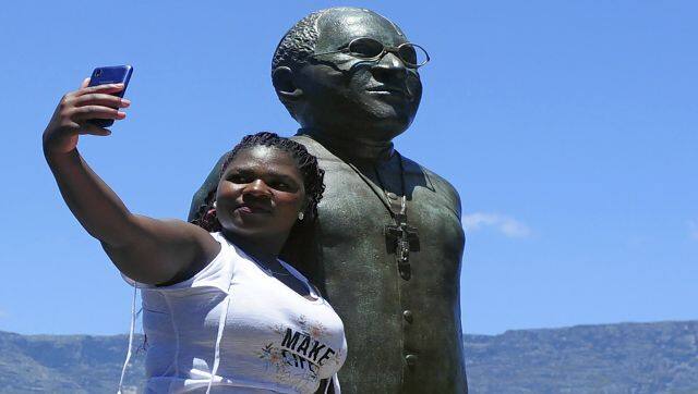 People take photos at a statue of Anglican Archbishop Desmond Tutu at the V&A Waterfront in Cape Town, South Africa. AP