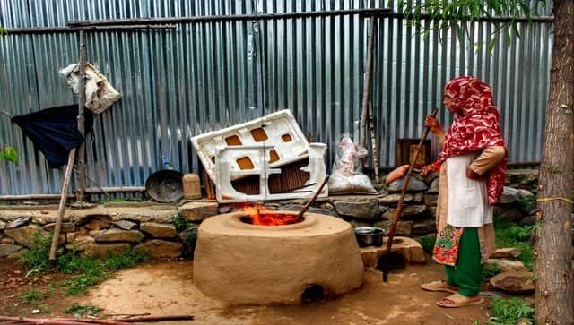  An Afghan woman in front of a clay oven or tandoor bakes bread to be served guests. Image courtesy: Mudasir Rawloo