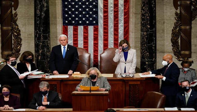 Vice President Mike Pence and Speaker of the House Nancy Pelosi, D-Calif., read the final certification of Electoral College votes cast in November's presidential election during a joint session of Congress after working through the night, at the Capitol in Washington. AP