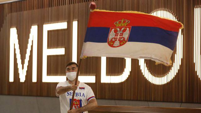 A fan of Serbia's Novak Djokovic in the arrivals hall at Melbourne Airport ahead of the Australian Open in Melbourne, Australia, Thursday, Jan. 6, 2022. Djokovic had received the medical exemption he needed to play at the Australian Open but the 20-time major champion was delayed by border officials from entering the country. (AP Photo/Hamish Blair)