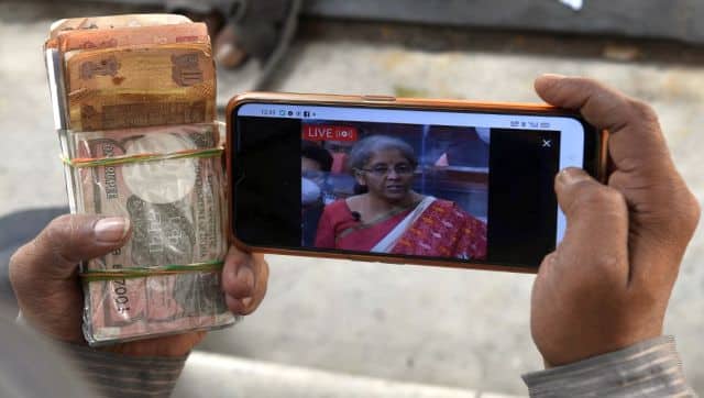File image of a man watching a live streaming of the 2021 Union budget on his mobile phone. AFP