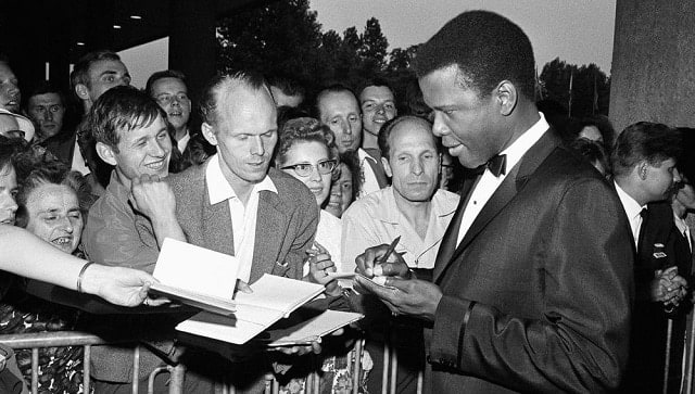 Sidney Poitier signs autographs before the opening of the 14th International Film Festival at the West Berlin congress hall on June 26, 1964 in Berlin. Poitier, the groundbreaking actor and enduring inspiration who transformed how Black people were portrayed on screen, became the first Black actor to win an Academy Award for best lead performance and the first to be a top box-office draw, died Thursday, Jan. 6, 2022. He was 94. (AP Photo/Edwin Reichert, File)