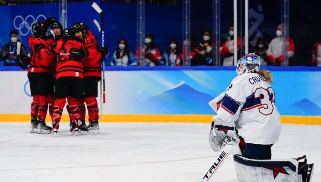 United States goalkeeper Alex Cavallini (33) kneels on the ice as Canada players celebrate after a goal by Marie-Philip Poulin during the women's gold medal hockey game at the 2022 Winter Olympics, Thursday, Feb. 17, 2022, in Beijing. (AP Photo/Matt Slocum)