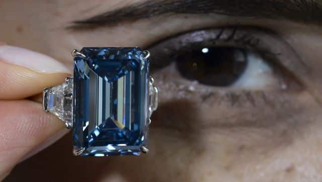 A woman holds up the 'Oppenheimer Blue,' a rare fancy vivid blue diamond weighing 14.62 carat. AFP