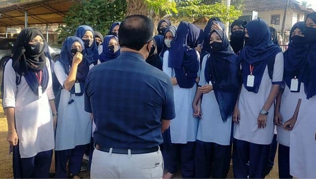 Indian girl students who were barred from entering their classrooms for wearing hijab, a headscarf used by Muslim women, speak to their principal outside the college campus in Udupi. AP