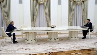 Emmanuel Macron sits across Vladimir Putin at long table after snubbing Russian COVID year