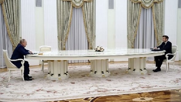 Emmanuel Macron sits across Vladimir Putin at long table after snubbing Russian COVID year