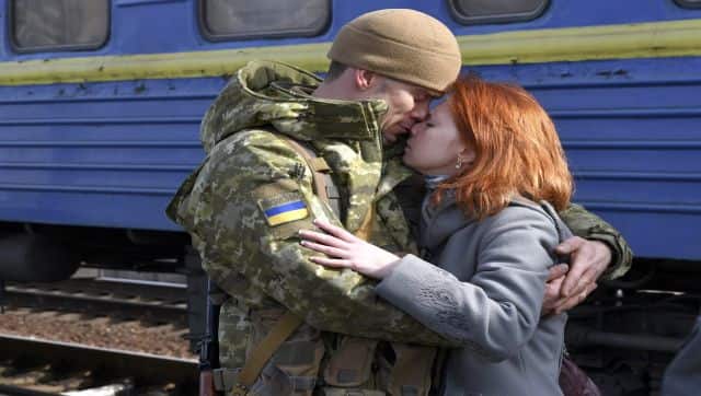 A couple embrace prior to the woman boarding a train carriage leaving for western Ukraine, at the railway station in Kramatorsk, eastern Ukraine. AP