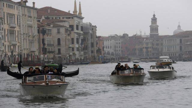 Taxi boats and tourists at the Canal Grande in Venice. Water taxis are a popular mode of transport in Venice. AFP