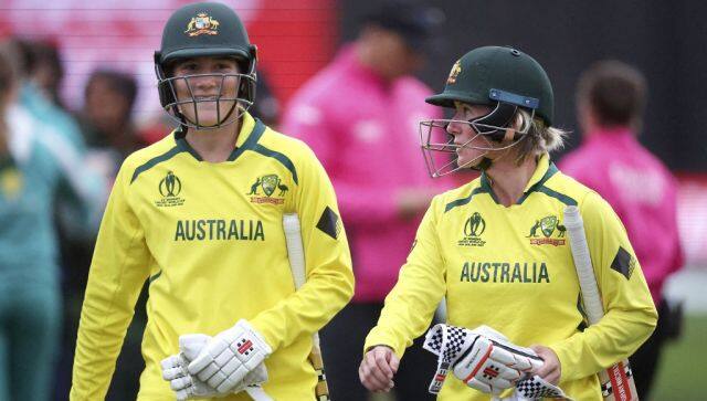 Australia's Beth Mooney (R) with teammate Annabel Sutherland walk from the field after their win during the Women's Cricket World Cup match between the Australia and Bangladesh at the Basin Reserve in Wellington on March 25, 2022. (Photo by Marty MELVILLE / AFP)