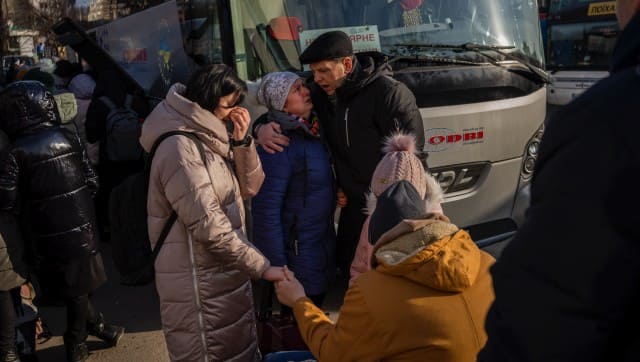 Ukrainian families say goodbye as they prepare to board a bus to Poland at Lviv bus main station, western Ukraine, Tuesday, March 1, 2022. Russian shelling pounded civilian targets in Ukraine's second-largest city Tuesday and a 40-mile convoy of tanks and other vehicles threatened the capital — tactics Ukraine’s embattled president said were designed to force him into concessions in Europe’s largest ground war in generations. (AP Photo/Bernat Armangue)