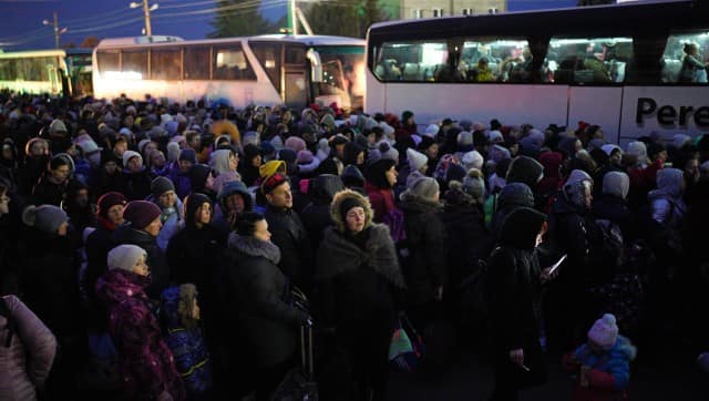 Refugees fleeing the war in Ukraine, form a line as they approach the border with Poland in Shehyni, Ukraine, Sunday, March 6, 2022. The number of Ukrainians forced from their country increased to 1.5 million and the Kremlin's rhetoric grew, with Russian President Vladimir Putin warning that Ukrainian statehood is in jeopardy. (AP Photo/Daniel Cole)