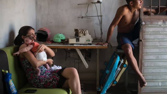 FILE - Angelica Pereira, left, holds her daughter Luiza, who was born with microcephaly because of the Zika virus, as she sits with her husband Dejailson Arruda, at their home in Santa Cruz do Capibaribe, Pernambuco state, Brazil on Dec. 23, 2015. (AP Photo/Felipe Dana, File, File)