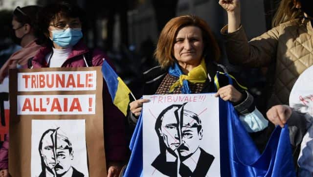 A woman holds a placard reading 