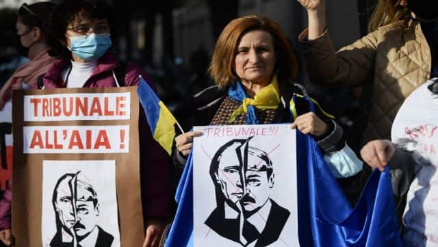 A woman holds a placard reading 