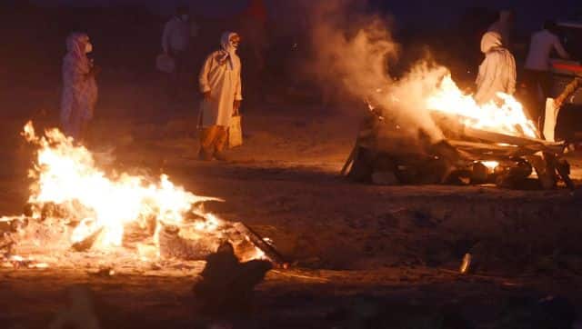 File image of relatives standing near the funeral pyre of their loved one who died due to the COVID-19 coronavirus at a cremation ground in Allahabad. AFP