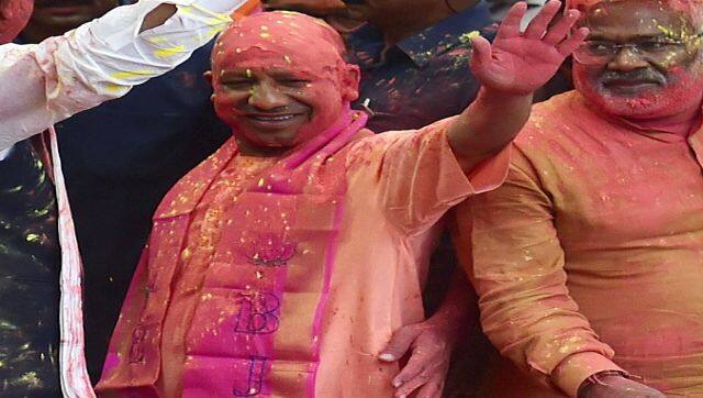 Chief Minister Yogi Adityanath gestures to his supporters after BJP's win in the state Assembly elections at the party office in Lucknow. AFP