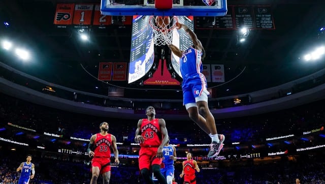Philadelphia 76ers' Tyrese Maxey, right, dunks the ball as Toronto Raptors' Pascal Siakam, center, and Gary Trent Jr., left, look on during the first half of Game 1 of an NBA basketball first-round playoff series, Saturday, April 16, 2022, in Philadelphia. (AP Photo/Chris Szagola)