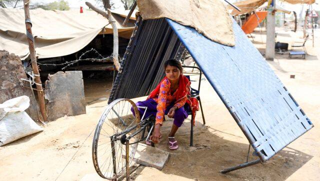 An Indian girl sits under a temporary shade made by joining two bed bases as she works on a roadside during a hot day in Churu, Rajasthan. The poor and the vulnerable are the most affected by the heatwave. AFP