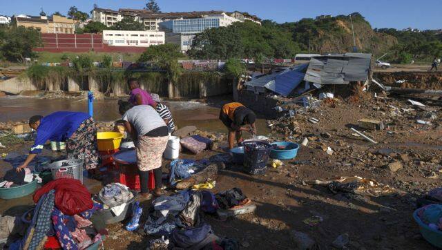 Residents of Quarry Road informal settlement wash their clothes as others rebuild in Durban following the devastating rains and flooding. AFP