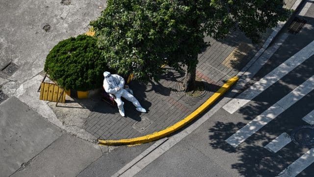 An officer wearing protective gear guards the entrance of a neighbourhood during the lockdown in Shanghai. AFP