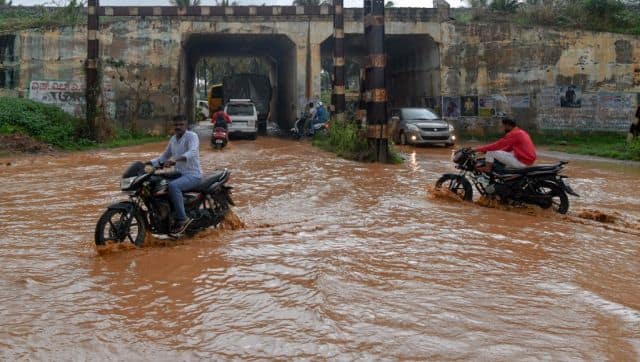 Motorists make their way through a waterlogged road after a rain shower in Bangalore on 18 May. AFP