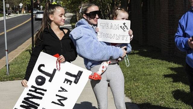 Sisters Esther Gunn, left, and Margaret Gunn wait near the security entrance outside the Fairfax County Historic Courthouse for a chance to see actor Johnny Depp's arrival in Fairfax, Virginia, April 27, 2022 (Valerie Plesch/The New York Times)