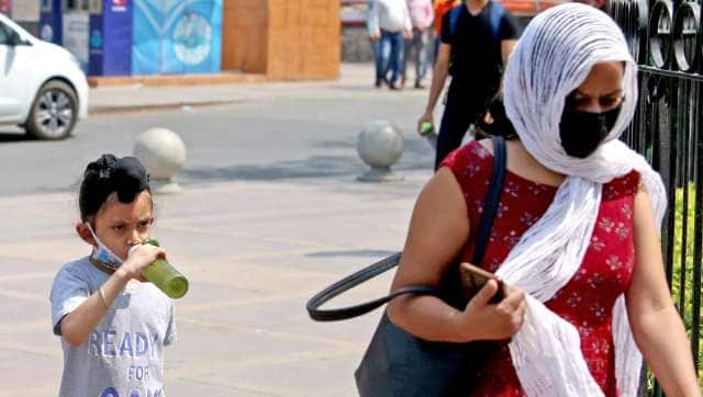 A woman covers herself with a scarf to protect herself from the sun on a hot summer day, in New Delhi. ANI